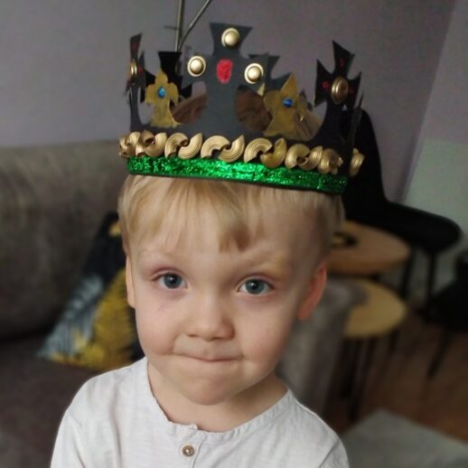 Dziecko z przykładową, własnoręcznie wykonaną koroną na głowie