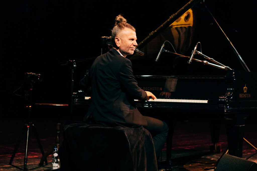 portret Adama Snopka przy fortepianie