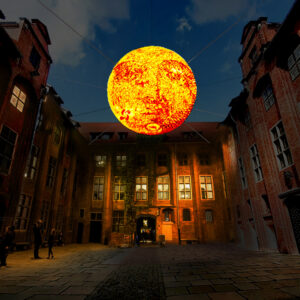 Na zdjęciu widać wielką kulę w formie Słońca zamontowaną nad dziedzińcem Ratusza Staromiejskiego.